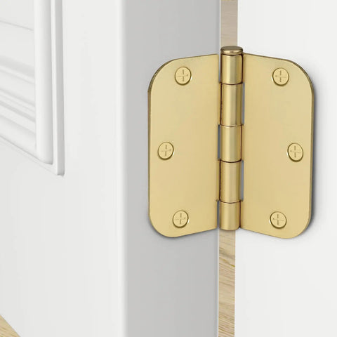 Close-up of a gold door hinge on a white interior door with visible screws, shown open to display hinge mechanism.