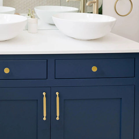 Premium Solid Metal Brushed Gold Cabinet Pulls on navy blue drawers beside white vessel sinks in modern bathroom.