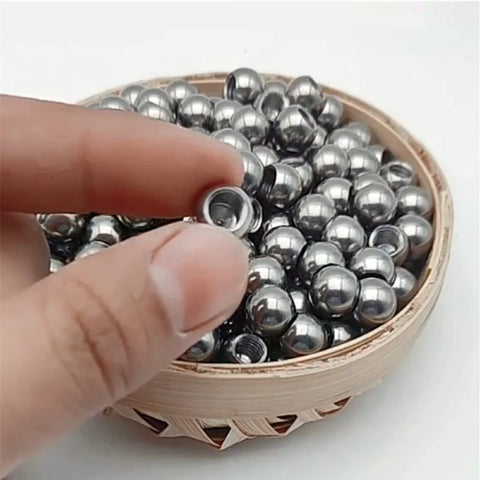 Stainless steel piercing replacement ball with M8 threaded hole; small silver sphere in wooden bowl