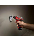 Person using Compact Cordless Driver Drill Kit Featuring Variable Speed Trigger And Quick Change Chuck on wall socket.