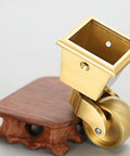 Heavy Duty Solid Brass Caster Wheels For Furniture With 32Mm Square Cup Mount And 360 Degree Swivel Base close-up of caster on wood base.