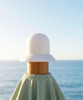 Stylish Patio Umbrella Top Cap Replacement Kit For Outdoor Canopies With Wind Resistance And Easy DIY Installation To Save Cash On Backyard Sun Shades. White top cap on wooden patio umbrella pole by the sea