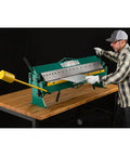 User operating 48 Inch Pan And Box Brake For 16 Gauge Sheet Metal, Heavy Duty Bench Type with interchangeable fingers on a workbench
