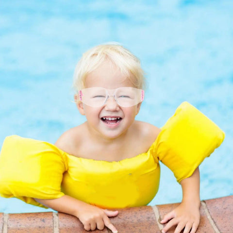 Happy child wearing Heavy Hitting Splash Guard Safety Glasses Six Pack with yellow floatation device by poolside.