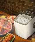 Solid Countertop Automatic Ice Maker For Kitchens Or Game Rooms Producing Fast Crystal Clear Cubes In Minutes With Low Key Push Button Controls and Stress Free Operation Perfect For Weekend Hangouts And Tailgate Party Vibes with ice cubes beside food.