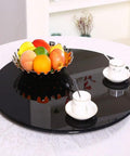 Smooth As Butter Lazy Susan Turntable For Dining Table with fruit bowl and tea cups on polished black glass surface.