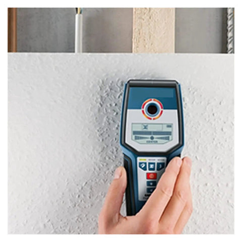 Stud Finder Wall Scanner with AC DC Voltage Test in hand against drywall, designed to detect hidden wooden studs and wires.