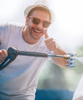 Man using 4 GPM High Pressure Washer Nozzle Kit With 4 Way Nozzles And One Quarter Inch Quick Connect For Soft Wash System Stainless Steel Tips