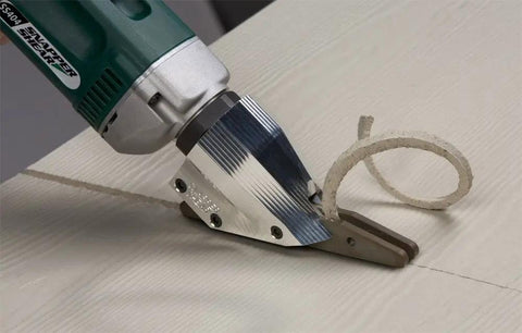 Pro Grade Heavy Duty Electric Fiber Cement Siding Cutter with Six Point Five Amp Motor slicing through fiber cement board.