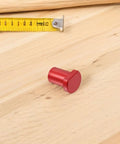 Red peg from Six Pcs Aluminum Alloy Workbench Peg Brake Stops With Low Profile Desktop Tenon Design For Woodworking on a surface