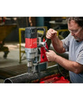 1-5/8 Inch Corded Magnetic Drill Kit With Variable Speed Control in use on steel pipe for precise hole drilling.