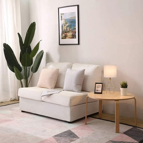 Living room scene with Gold Modern Hollow Out Base Table Lamp With White Fabric Shade on side table beside white sofa.