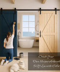 Woman painting a Twenty By Eighty Four Inch Unfinished Spruce Barn Door With Modern British Brace Design in a bright bathroom.