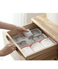 Slick Four Compartment Plastic Underwear Storage Box For Closet Dresser Drawers, organizing socks and leggings in a wooden drawer.