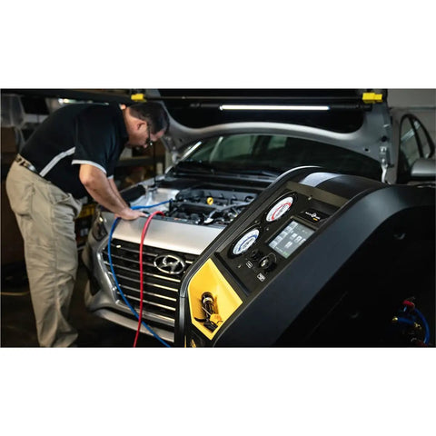 Technician using Shop Floor Legend R1234yf Auto AC Refrigerant Recovery Recycle Recharge System With Wireless Sync Seven Inch HD Touchscreen in garage.