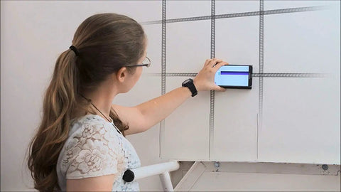 User scanning a wall with Fo Sho Reliable Android Only Smart Wall Detector for studs and wires detection.