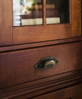 Vintage Half Moon Cup Pulls 30 Pack Pressed Steel Cabinet Handles on wooden drawer with rustic finish.