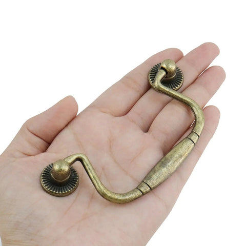 Set Of 10 Hella Sturdy Antique Bronze Cabinet Knobs And Bail Pulls With 3.1 Inch Hole Spacing Heavy Duty Zinc Alloy Construction showing a bail pull in hand.