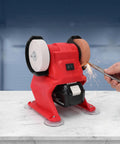 Heavy Duty Badass Mini Bench Grinder Featuring Dual 70 Mm Wheels Kicking Out 5500 Rpm For Rad Metal Shaping And Deburring Using Any 18V Battery Pack For Your Workshop, red design with grinding sparks.