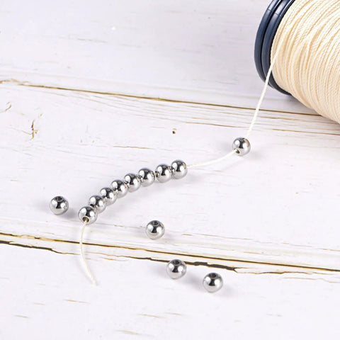 Smooth And Sturdy 40 Piece Pack 6 Millimeter Round Stainless Steel Spacer Beads Featuring 3 Millimeter Center Holes Slick Silver Finish on thread.