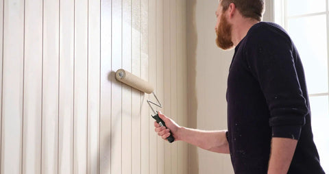 Person painting a wall using R523 18 Inch Microfiber Paint Roller Cover Three Eighths Inch Nap Pack Of 6 for smooth finish and strong paint pickup.
