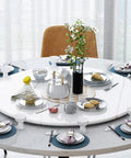 Built Tough 23 Inch Marble Lazy Susan With Butter Smooth 360 Degree Swivel Action And Rock Solid Nonslip Base set on a dining table filled with dishes.