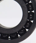 Close-up view of Dead Serious High Temperature Chrome Steel Full Ball Bearings 50X80X10mm TB16010 with black manganese phosphate coating.