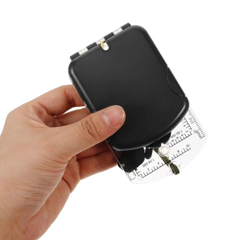 Hand holding Multi Function Hiking Compass With Luminous Scale, Mirror, And Ruler for camping and survival use