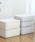 Stackable White Plastic Drawer Organizers For Bras Socks And Underwear Open Top Storage Bins neatly stacked on a wooden floor.