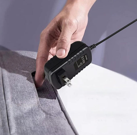 Heavy Duty 12V AC To DC Wall Charger Supplied With Beefy Power Output connected to a standard outlet with a hand.