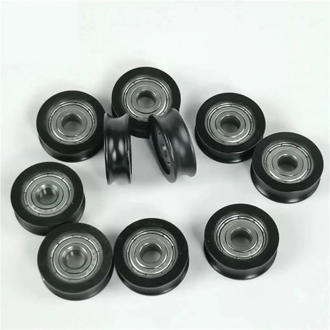 Five Pack Heavy Duty Nylon U Groove Rolling Sliders With Knockout Black Finish Super Slick Slide Flanged Track Wheels Ideal For Window And Door Tracks Featuring 20 MM Outer Diameter And 5 MM Inner Bore For Top Shelf Smart Fixes And Easy Repairs - angled view of black nylon sliders with steel bearings.