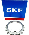 Pro Grade W11 Lock Washer For Bearings With 2.18 Inch Inner Diameter And 3.109 Outer Diameter 0.053 Inch Width placed beside SKF packaging.