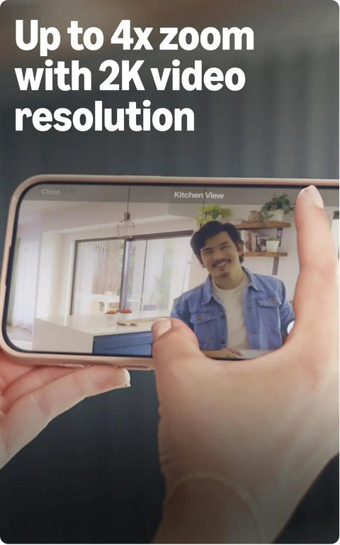 Person on phone screen demonstrating Mini 2K Plus Plug In Indoor Security Camera For Home And Pets with 2K Video and 4x zoom.