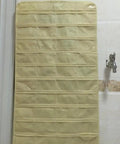 Keep Your Jewels In Check with This Double Sided Hanging Jewelry Organizer Featuring 80 Transparent Pockets for Earrings Necklaces and Bracelets made from Durable Nonwoven Fabric Super Lightweight and Travel Ready Perfect Wardrobe Closet Stash Solution in beige hanging on a wall.