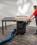 Folding Table Saw Outfeed Kit With Adjustable Height Legs And Foldable Steel Frame in use with woodworker at saw.