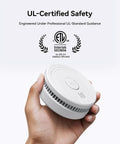 Top Shelf Smoke Detector And Home Fire Alarm Powered By 9V Batteries With Smart Adaptive Sensors in a hand for scale.