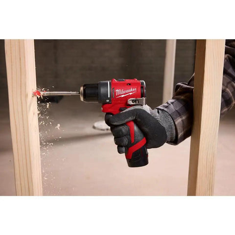 Hand using Subcompact Brushless 3/8 Inch Drill Driver Kit for Tight Spaces on wood, showing torque and power.