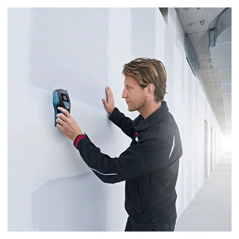 Man using Hands Down Best Pro Grade Wall Scanner to detect live wires and studs on a wall in a construction setting.