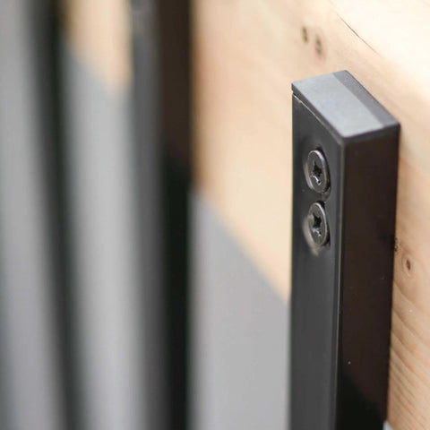 Close-up of Rectangular Baluster One Inch By Half Inch, Thirty Two Inch Long, Built Tough Heavy Gauge Galvanized Steel With Powder Coated Black Finish attached to wood surface for railings and stairs.