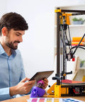 Man using tablet near 3D printer with Kickstart Your Build 4 Pack 2020 T Slot Aluminum Extrusion Profile Black Anodized Linear Guide Rails 200 mm.