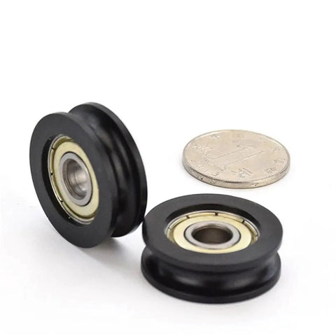 Five Pack Heavy Duty Nylon U Groove Rolling Sliders With Knockout Black Finish Super Slick Slide Flanged Track Wheels Ideal For Window And Door Tracks Featuring 20 MM Outer Diameter And 5 MM Inner Bore For Top Shelf Smart Fixes And Easy Repairs, showing two black nylon sliders next to a coin.