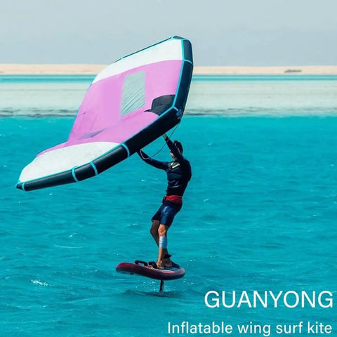 Person using Inflatable Wing Foil With Handheld Wing, Surf Wing And Wind Foil, in blue water, wearing wetsuit.