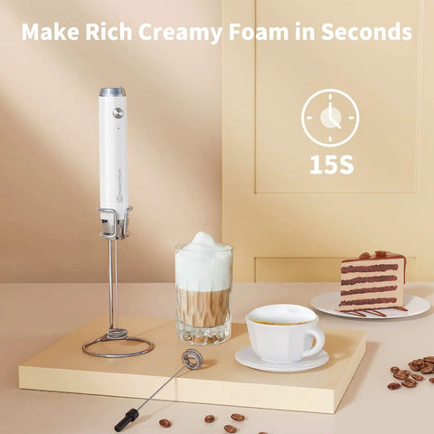 Rechargeable Milk Frother With 3 Heads, USB C Handheld Foam Maker, Waterproof Detachable Stainless Steel Whisk, Stand Included, Electric Drink Mixer For Lattes And Cappuccinos, Rich Foam Anytime shown with a cappuccino and slice of cake.