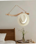 Badass 16 Inch Natural Wood Wall Hooks Featuring Five Curved Prongs For Hanging Heavy Jackets Tote Bags And Key Chains Inside Your Mudroom Or Entryway While Keeping Everything Slick And Organized, showcasing a hat on rustic driftwood.