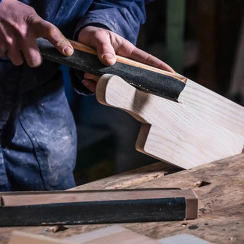 Person using Pro Grade Wet Dry Sandpaper Kit with 5 Sheets of 9x3.6 Inch Waterproof Grit on a wooden surface.