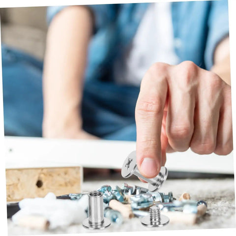Person holding a carbon steel binding screw above scattered fasteners, showcasing silver finish and no sweat twist lock system.