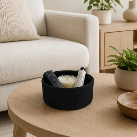 Super Handy Small Woven Cotton Rope Basket For Versatile Home Organization Black Storage Bin For Remotes Keys And Household Gear That Keeps Your Place Real Cool And Neat Daily with remote and candle on wooden table.