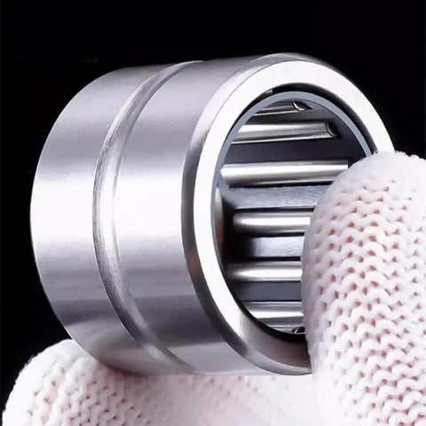 Top Shelf Machined Needle Roller Bearing Set With Heavy Duty Outer Ring Flanges And Tight Guided Cages held in hand, showcasing precision engineering.