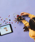 Girl assembling a spider model from the Awesome Building Kit Featuring Rad Spider Scorpion And Snake Models Hella Fun Creative Playset For Kids Ages 7 Plus.
