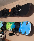 Rock Solid Aluminum Wall Mount Snowboard Rack With Hella Secure Eva Grip Pads To Keep Your Boards Locked Down Safe For Garage Or Home Storage Layouts Includes Two Heavy Duty Rack Units holding two snowboards on a wall.